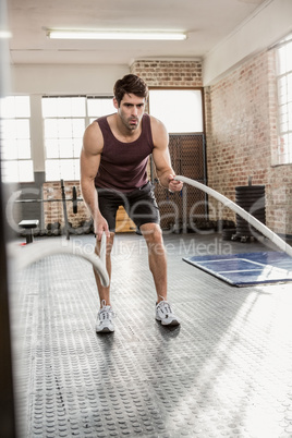 Man exercising with battling rope