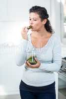 Beautiful pregnant woman eating a pickle