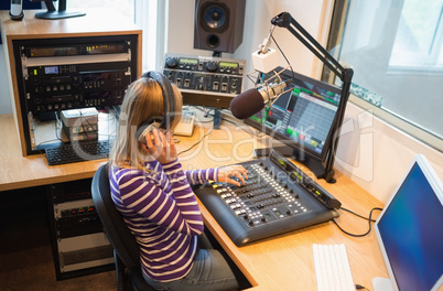 Female radio host operating sound mixer
