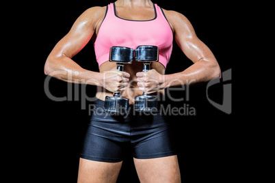 Midsection of woman doing workout with dumbbells