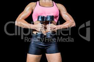 Midsection of woman doing workout with dumbbells