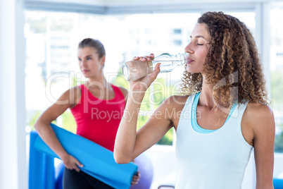 Woman drinking water in fitness studio