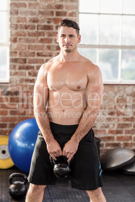 Muscular man lifting a kettlebell