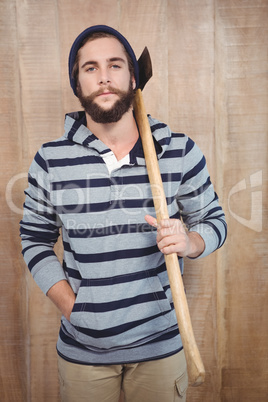 Portrait of hipster with hooded shirt holding axe