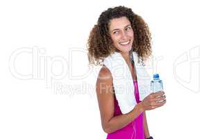 Cheerful young woman with towel holding bottle