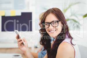 Portrait of smiling woman wearing eyeglasses while holding smart