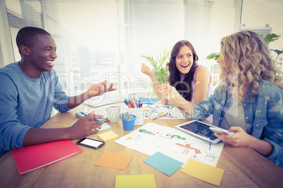 Happy business people working at desk in creative office