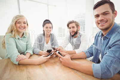 Portrait of smiling business people using smartphones