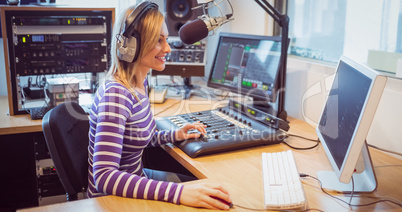 Female radio host broadcasting through microphone