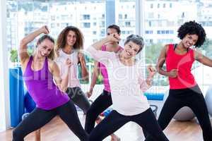 Portrait of cheerful women exercising with clasped hands