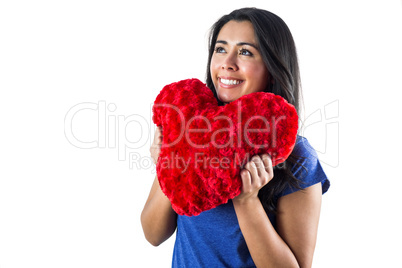 Smiling woman holding a heart shaped pillow