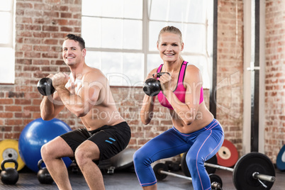 muscular smiling couple with kettlebells