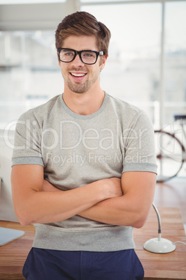 Happy hipster wearing eye glasses leaning at desk
