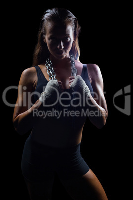 Portrait of female fighter holding chain around neck