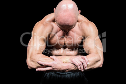 Bodybuilder flexing muscles while looking down