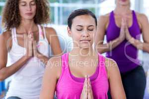 Women meditating with joined hands