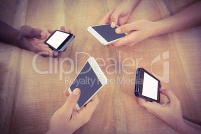 High angle view of cropped hands using mobile phones at desk