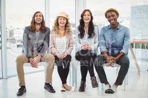 Full length portrait of happy business people sitting on chair