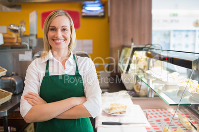 Confident female shop owner standing by display cabinet