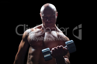 Concentrated bodybuilder lifting dumbbell