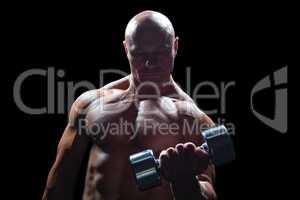 Concentrated bodybuilder lifting dumbbell