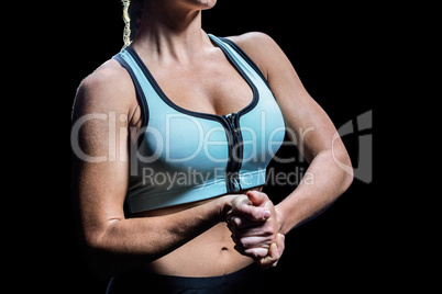 Midsection of fit woman stretching hands