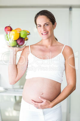 Portrait of happy woman with fruit bowl