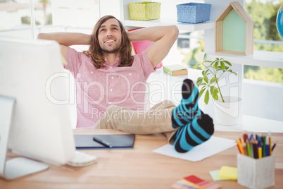 Hipster relaxing with legs on desk