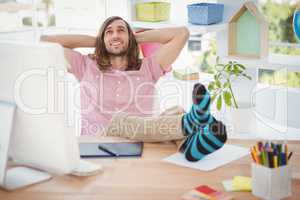 Hipster relaxing with legs on desk