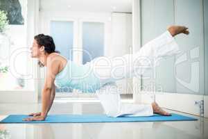 Confident pregnant woman performing yoga on mat