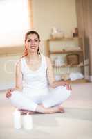 Portrait of smiling woman meditating on floor