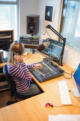 High angle view of female radio host operating sound mixer