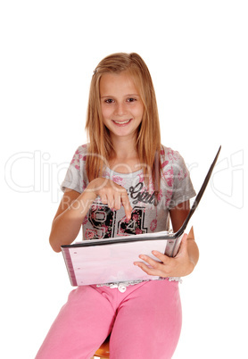 Schoolgirl pointing at her book.