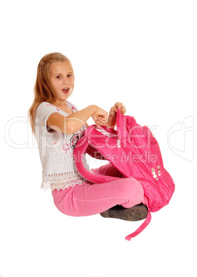 Surprised girl pointing on backpack.