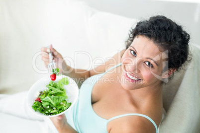 Portrait of happy woman eating salad