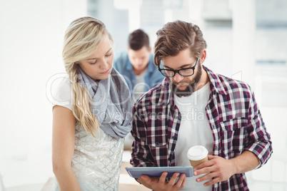 Man and woman working on digital tablet