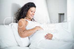 Attractive pregnant woman resting in bed