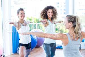 Smiling women doing warrior II pose