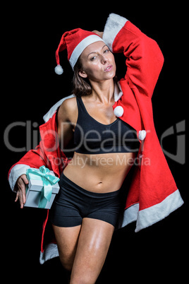 Portrait of sexy athlete in Christmas costume while holding pres