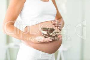 Midsection of woman with baby boots in hand