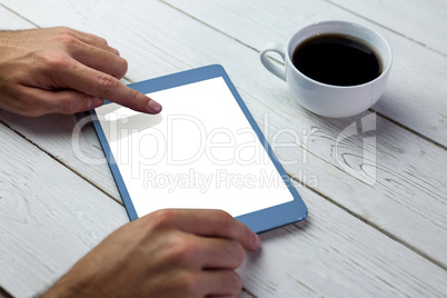 Person using tablet on wooden table