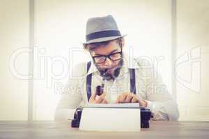 Hipster smoking pipe while working in office