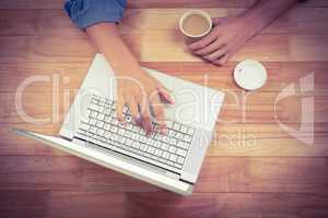 Man holding tea while working on laptop