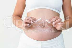 Close-up of pregnant woman destroying cigarette