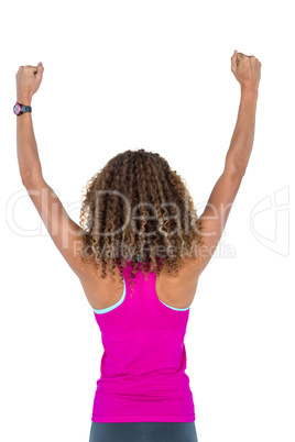 Rear view of woman cheering with arms raised