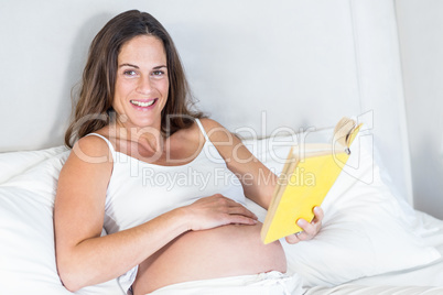Portrait of pregnant woman with novel