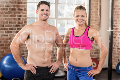 Standing muscular couple facing the camera
