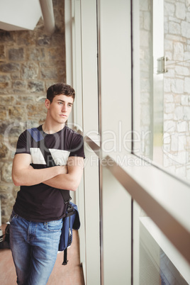 Thoughtful male student with arms crossed