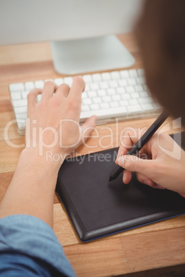 Businessman using graphics tablet on desk in office Businessman using graphics tablet on desk in office