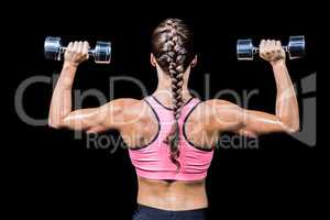 Rear view of braided hair woman exercising dumbbells